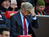 Arsene Wenger runs his fingers through his hair in frustration