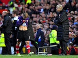 Jack Wilshere walks off the pitch while being eyed by Arsene Wenger