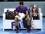 Roger Federer sits with his head down
