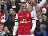 Lukas Podolski smiles after scoring Arsenal's second on November 17, 2012