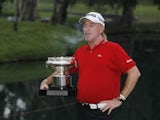 Miguel Angel Jimenez having a fag while posing with his trophy on November 18, 2012