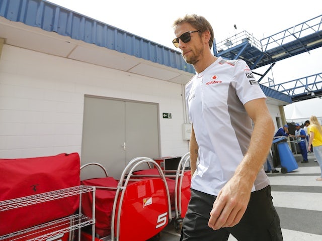 Practice leader Jenson Button walks into the pitlane in Brazil on November 24, 2012