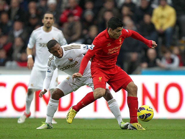 Jonathan de Guzman attempts to challenge Luis Suarez for the ball on November 25, 2012
