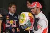 Fastest qualifier Lewis Hamilton shows off his Brazilian flag helmet on November 24, 2012