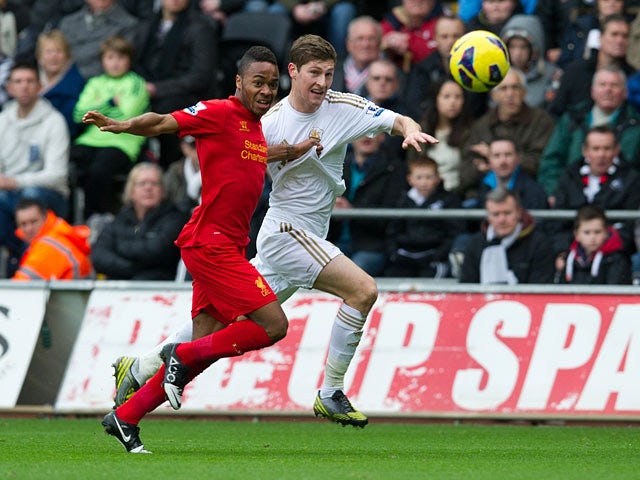 Raheem Sterling tugs the shirt of Ben Davies as they chase the ball on November 25, 2012