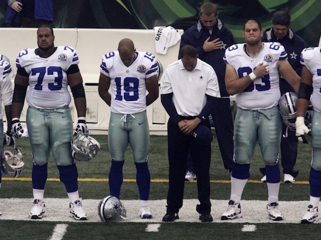 Cowboys players bow their heads in memory of killed teammate Jerry Brown, before their game with the Bengals on December 9, 2012