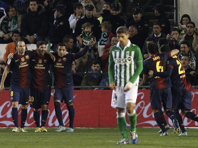 Lionel Messi celebrates with teammates after scoring his first against Betis on December 9, 2012