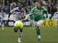 Lyon's Bafe Gomis challenges for the ball with Saint-Etienne's Loic Perrin on December 9, 2012