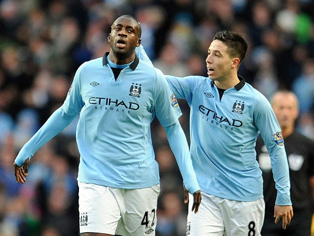 Yaya Toure is congratulated by Samir Nasri after scoring his team's first goal on December 9, 2012