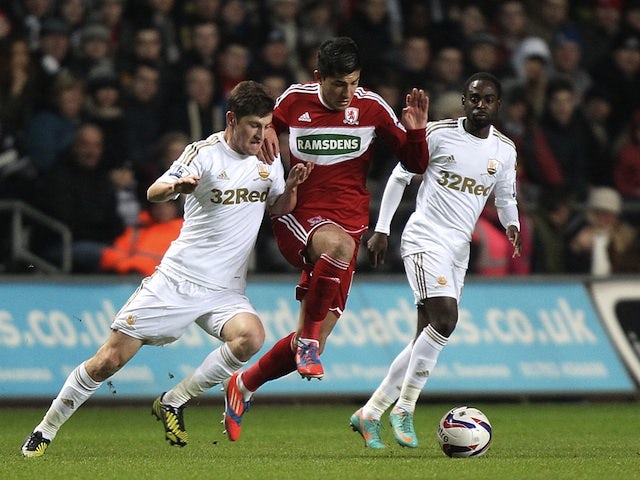 Middlesbrough's Emmanuel Ledesma battles for possession with two Swansea players on December 12, 2012