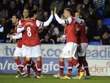Arsenal players congratulate Lukas Podolski after he opened the scoring against Reading on December 17, 2012