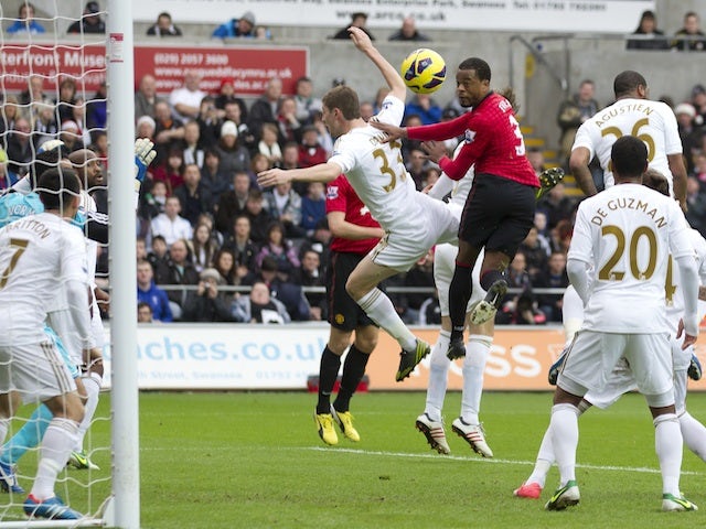 United's Patrice Evra jumps highest to open the scoring against Swansea on December 23, 2012