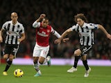 Theo Walcott and Fabricio Coloccini battle for the ball on December 29, 2012