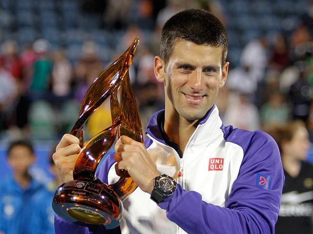 Novak Djokovic poses with the trophy after winning to defend his World Tennis Championship in Abu Dhabi on December 29, 2012