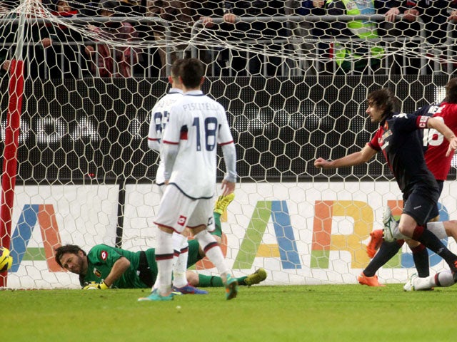 Two Genoa players look on at Daniele Conti scores Cagliari's winner in their Serie A clash on January 13, 2013