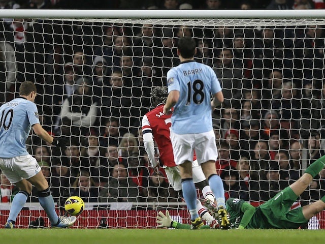City forward Edin Dzeko taps in the second goal against Arsenal on January 13, 2013