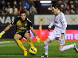 Real Madrid's Jose Callejon and Osasuna's Andres Fernandez battle for the ball on January 12, 2013