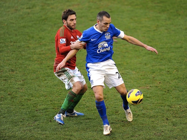 Everton midfielder Leon Osman battles with Swansea's Angel Rangel during the game on January 12, 2013