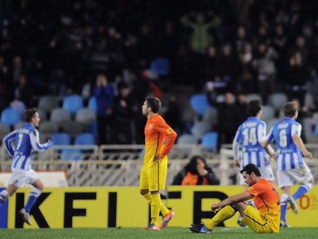 Barcelona players are dejected on the pitch following a late goal and a loss against Real Sociedad on January 19, 2013