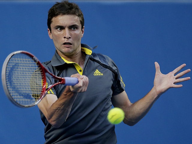 Gilles Simon hits a return to Gael Monfils during their third round match at the Australian Open on January 19, 2013