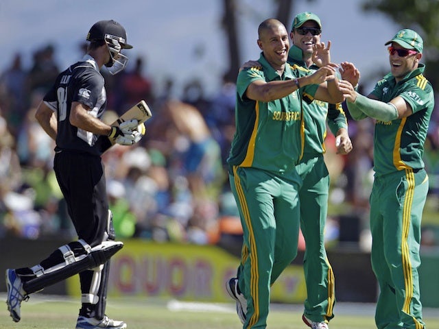 South Africa's Rory Kleinveldt is congratulated by his teammates after taking the wicket of NZ's Grant Elliot on January 19, 2013