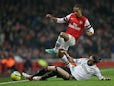 Chico Flores and Theo Walcott battle for the ball during the FA Cup third round replay on January 16, 2013