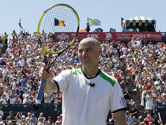 Former Tennis star Andre Agassi waves to the crowd during an exhibition match on July 10, 2011