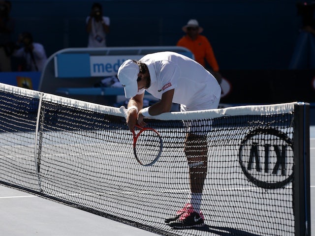 Frenchman Jeremy Chardy rests on the net following his straight-sets defeat to Andy Murray on January 23, 2013