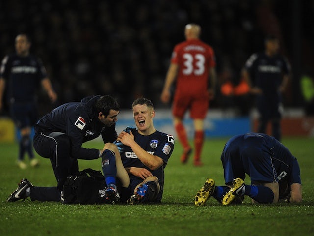 Oldham hero Matt Smith winces in pain following a shoulder injury in the game against Liverpool on January 27, 2013