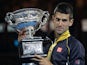 Novak Djokovic poses with the trophy after defeating Andy Murray in the men's final at the Australian Open on January 27, 2013