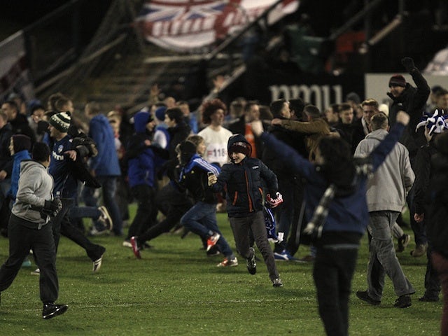 Oldham fans invade the pitch following their historic fourth round victory over Liverpool on January 27, 2013