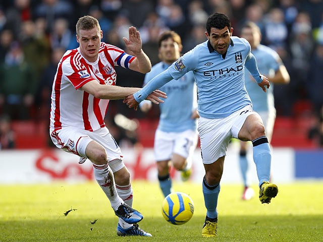 Ryan Shawcross and Carlos Tevez battle for the ball during their FA Cup fourth round tie on January 26, 2013