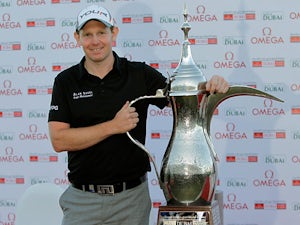 Stephen Gallacher poses with the trophy after winning the Dubai Desert Classic Golf tournament in Dubai on February 3, 2013