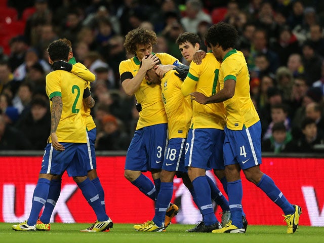 Teammates congratulate Brazil player Fred after scoring against England on February 6, 2013