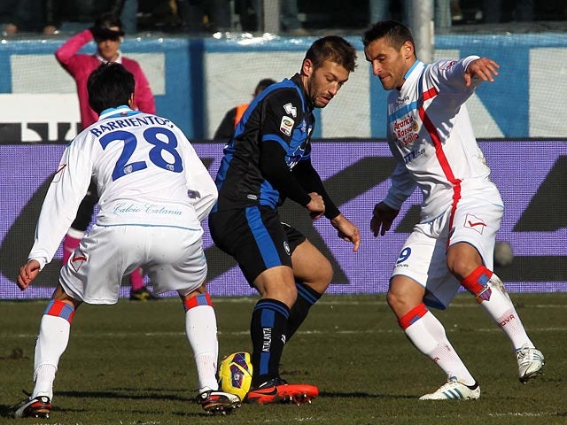 Catania's Gonzalo Ruben Bergessio and Pablo Cesar Barrientos defend against Atalanta's Michele Canini on February 10, 2013