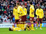 Arsenal's Jack Wilshere lays injured while teammates look on during his side's game with Sunderland on February 9, 2013