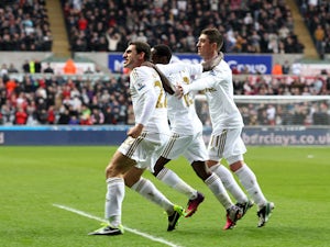 Swansea City's Angel Rangel celebrates alongside teammates after he scored against QPR on February 9, 2013