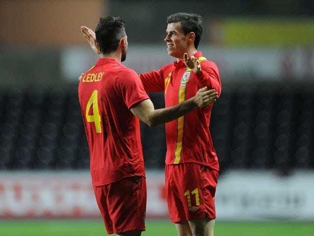 Wales player Gareth Bale celebrates with a teammate after scoring his side's opening goal on February 6 , 2013