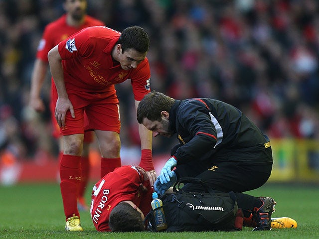 Stewart Downing checks on team mate Fabio Borini as he is attended to by the physio after picking up an injury during the match against Swansea on February 17, 2013