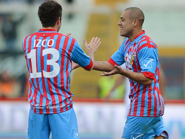 Catania's Sergio Almiron is congratulated by team mate Mariano Izco after scoring the opener against Bologna on February 17, 2013