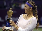 Victoria Azarenka displays the Qatar WTA Ladies Open tennis trophy after defeating Serena Williams in the final on February 17, 2013