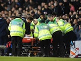 Spurs' Emmanuel Adebayor is stretched off injured during the game with Arsenal on March 3, 2013