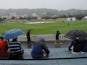 Spectators shelter as rain falls during day four of the Second Test match between New Zealand and England on March 17, 2013