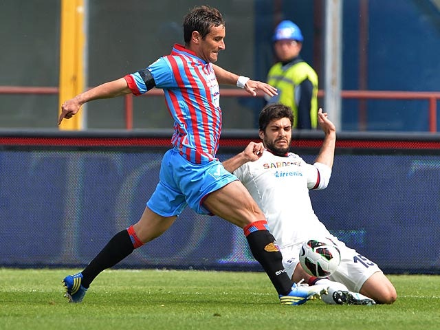 Catania's Gonzalo Bergessio and Cagliari's Luca Rossettini battle for the ball on April 7, 2013