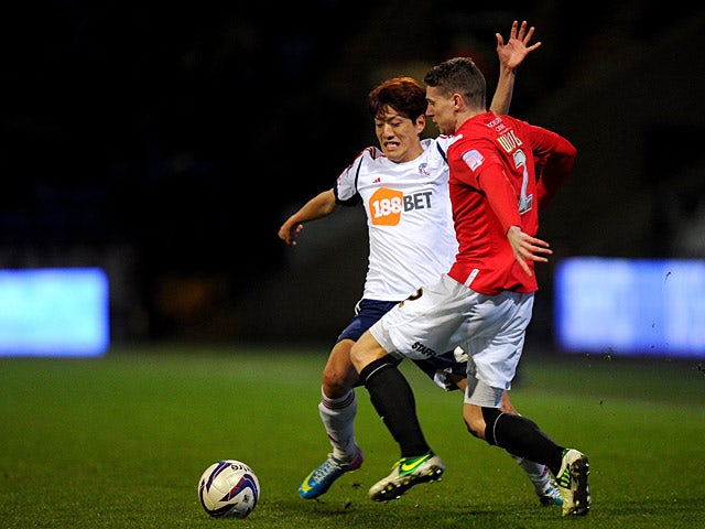 Bolton's Lee Chung-Yong and Huddersfield's Calum Woods battle for the ball on April 2, 2013