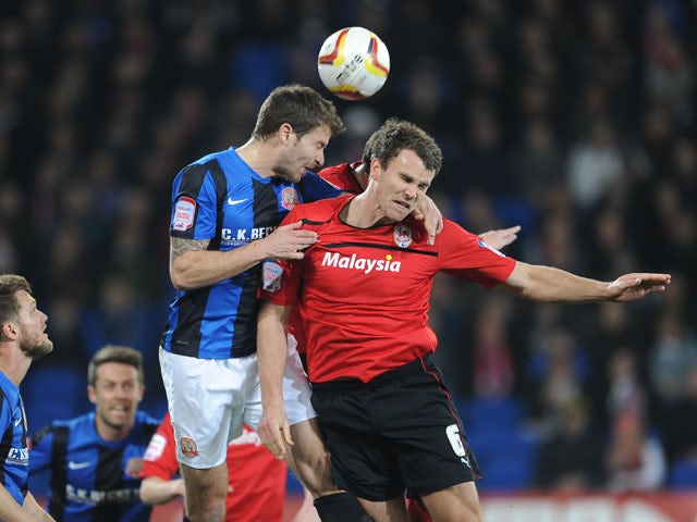 Cardiff City's Ben Turner and Barnsley's Richard Foster battle for the ball during the Championship match on April 9, 2013