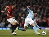 Carlos Tevez and Ryan Giggs battle for possession during the Manchester Derby on April 8, 2013