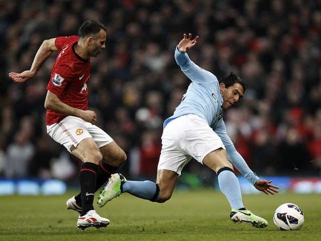 Carlos Tevez and Ryan Giggs battle for possession during the Manchester Derby on April 8, 2013