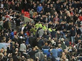 Trouble breaks out in the stands between Milwall fans and police during the match between Wigan and Millwall on April 13, 2013