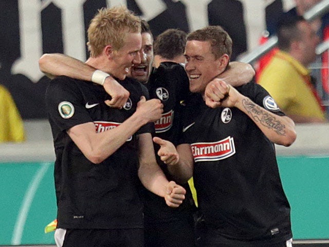 Freiburg's Jan Rosenthal is congratulated by teammates after scoring the equaliser against Stuttgart on April 17, 2013